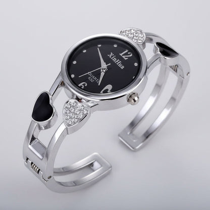 Silver bracelet watch with black dial on a black background
