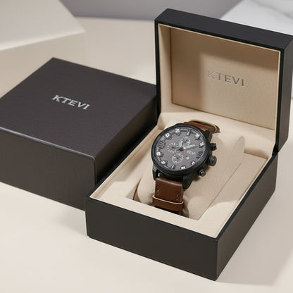 Hand holding a brown leather watch with a detailed face, brand 'KTEVI' visible.