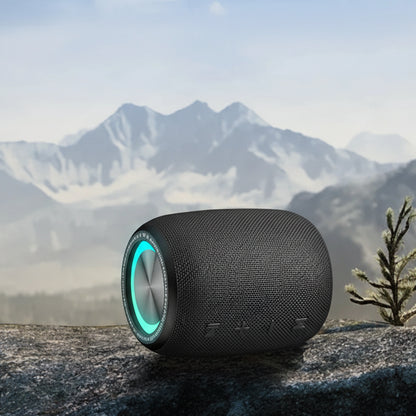 Black portable speaker with 1500mAh battery capacity on a mountain background